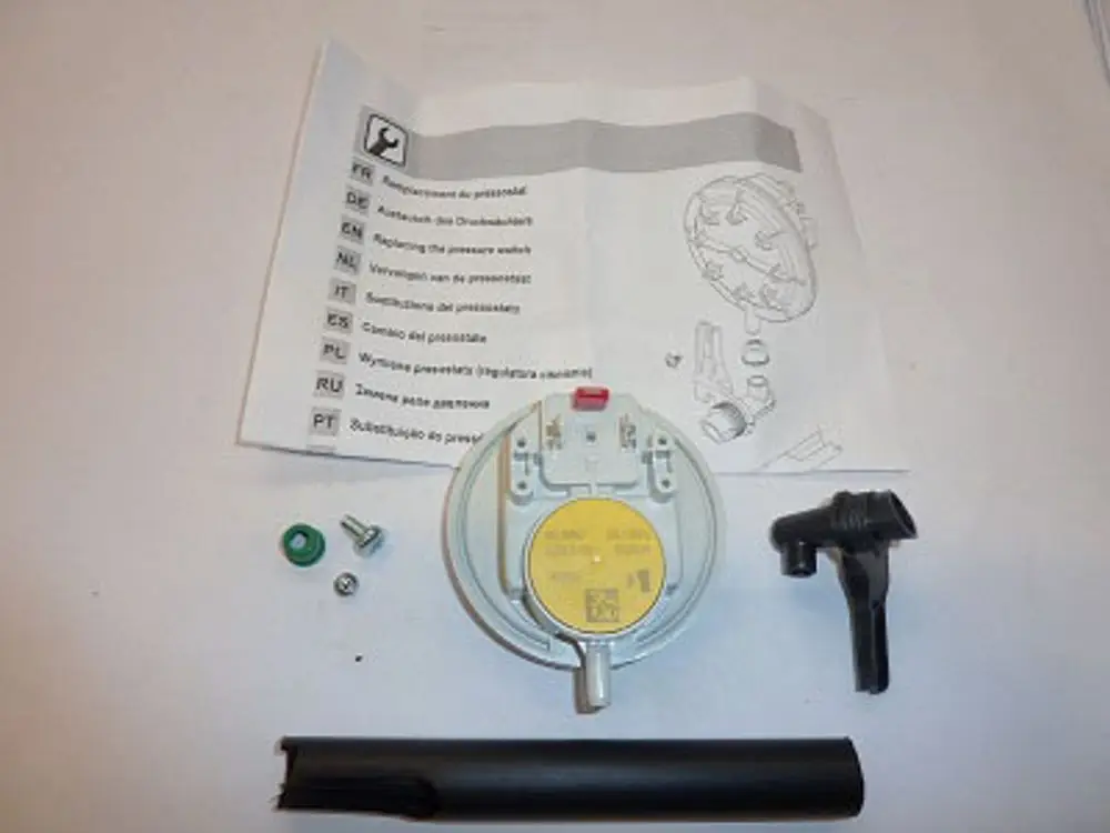 Montagezubehör für den Luftdruckwächter von Remeha. Enthält einen Sensor, Schrauben, Dichtungen und eine Anleitung in mehreren Sprachen.